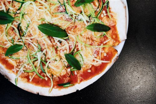 Hinter »Die grüne Schlange« verbirgt sich eine Pizza mit Zucchini-Spiralen, Mozzarella, Salbei, Pinienkernen, Parmesan und hausgemacht Tomatensauce.