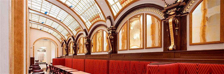 Die Gasträume sind unter stilvollen Gewölbedecken bzw. in einem mit Stuckverzierungen und Figuren dekorierten Gang gelegen.