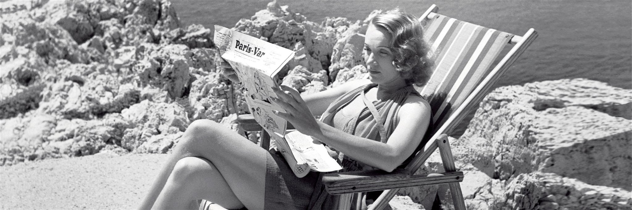 Marlene Dietrich bei der Lektüre des »Paris-Var« am Strand des »Eden-Roc«.