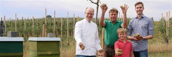 Philipp Ferber (links), Küchenchef des »Breidenbacher Hof« mit Christian Benninghoven, dessen Familie und der ersten Ernte der eigenen Kartoffeln.