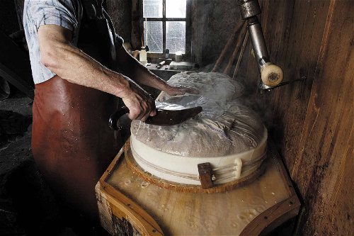 Nach Erreichung der richtigen Temperatur und richtiger Größe, werden Molke und Käsebruch in runde Formen gefüllt und rund zwanzig Stunden gepresst.