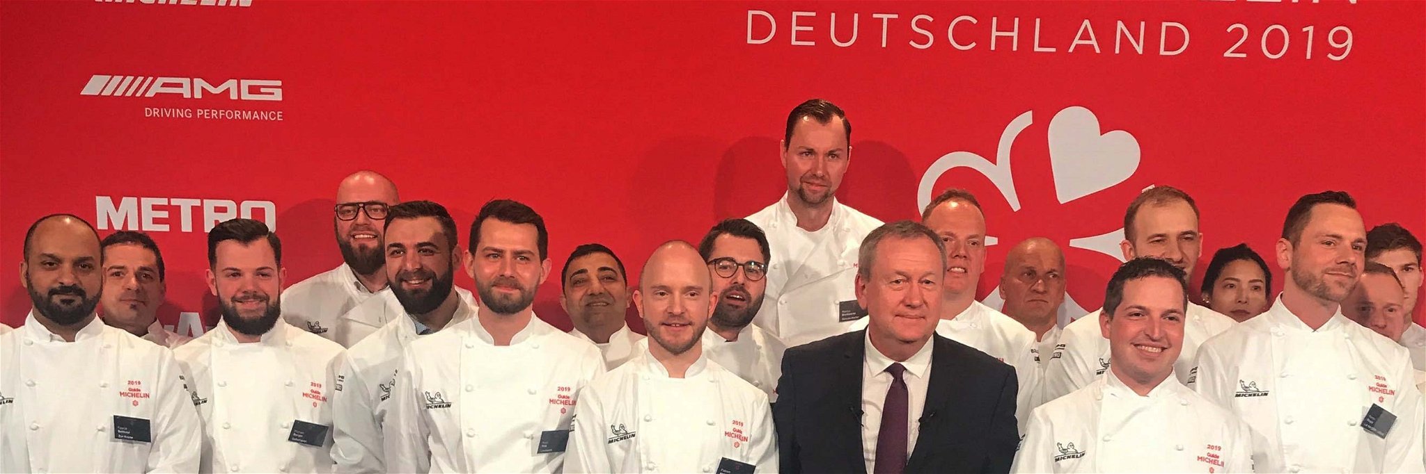 Lars Volbrecht steht rechts hinter Pascal Couasnon, CEO Michelin Food&amp;Travel, auf der Bühne in Berlin.