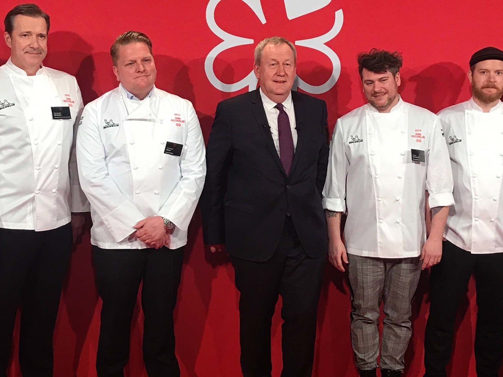 Pascal Couasnon, CEO Michelin Food&amp;Travel, mit den Köchen der neuen Zwei-Sterne-Restaurants.