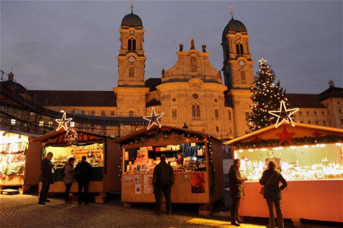 Weihnachtsmarkt Einsiedeln Auf dem Klosterplatz steht ein grosser Weihnachtsbaum und heimelig dekorierte Verkaufsstände. Der gesamte Markt erstreckt sich vom Kloster bis zum Bahnhof.