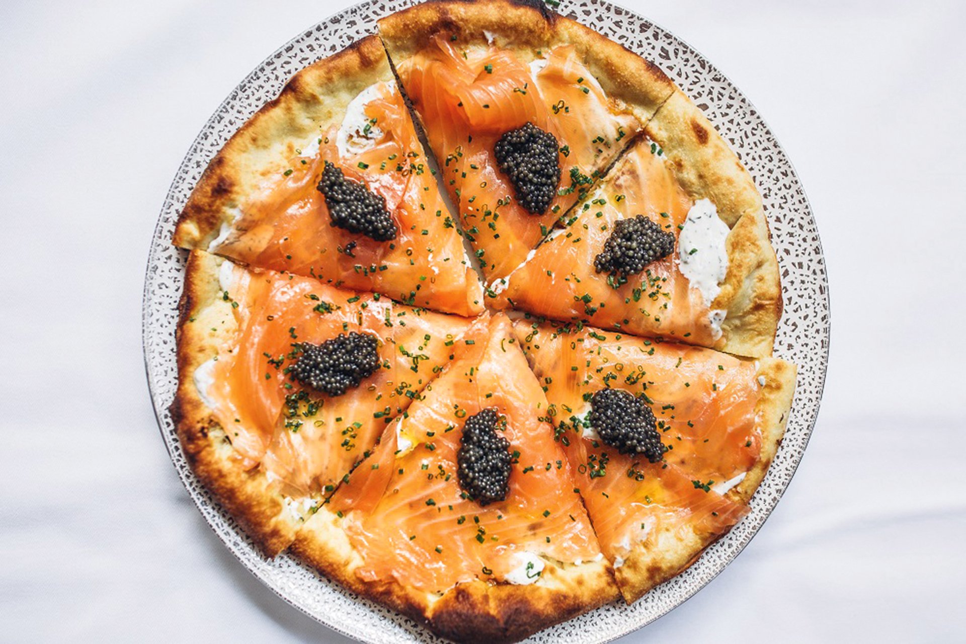 Puck-Kreation Pizza mit Räucherlachs und Kaviar.