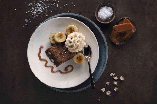 Schokolade-Haselnuss-Brownie mit gebratenen Rum-Bananen und Salty Caramel.