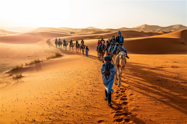 A caravan winds its way through Merzouga in the Sahara desert.