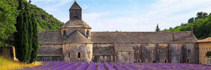 Abbaye Notre-Dame de Sénanque surrounded by rows of lavender in Provence.