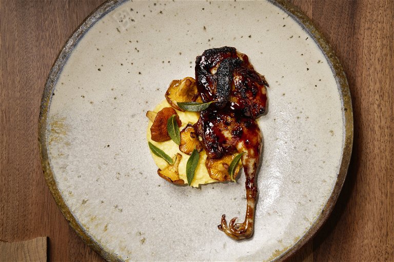 Grilled quail with fresh corn polenta and chanterelles.