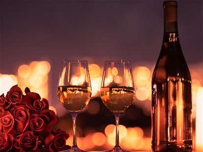 Valentinstag-Dinner mit Wein und roten Rosen.