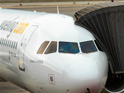 Barcelona, Spain - September 24, 2021: Airbus A321 of the Vueling company with the "finger" aircraft access gangway attached, preparing for the take-off flight in the airport El Prat