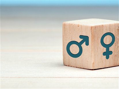 Male and female gender icons or symbols on two sides of a wooden cube. Gender equality concept.
