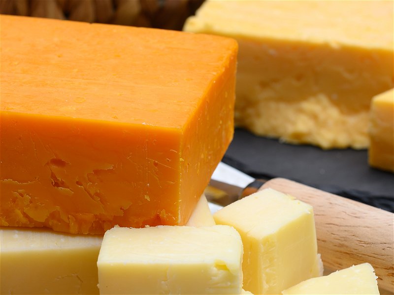 British hard cheeses made from cow milk yellow matured cheddar from Somerset and red leicester