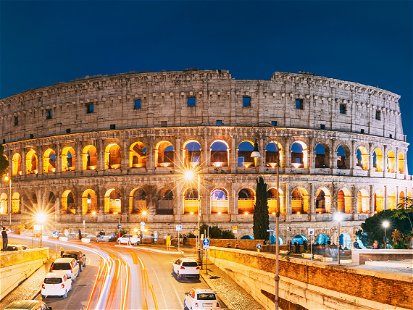 Rome, Italy. Colosseum Also Known As Flavian Amphitheatre. Traffic In Rome Near Famous World Landmark In Evening Time. Famous World Landmark UNESCO