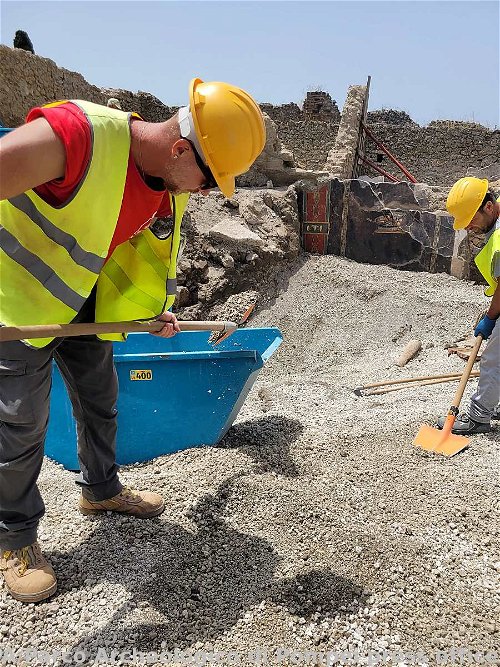 Arbeiter bei Ausgrabungen neben einem 2.000 Jahre alten pompejanischen Fresko.