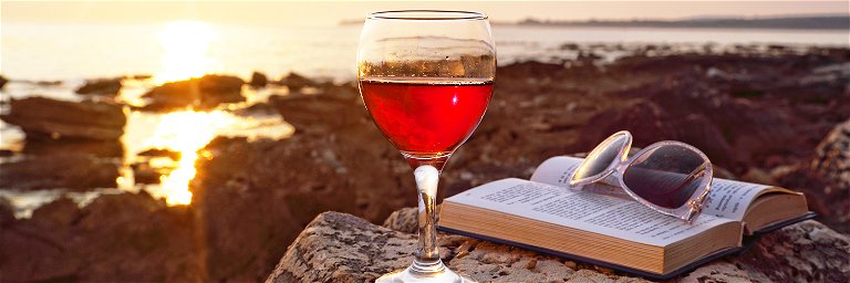 Sonnenuntergang mit einem Glas Wein und dem aktuellen Lieblingsbuch – Was gibt es Schöneres? 