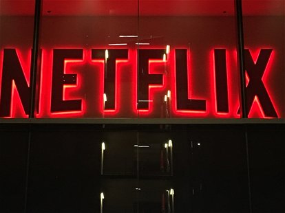 LOS ANGELES, CA, AUG 2018: entrance to streaming video-on-demand company, Netflix offices in Hollywood at night, with giant video screens partially visible in lobby, focus on corporate logo above door