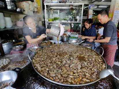 Bangkok, Thailand - June 27, 2023: A giant pan full of stewed beef and goat meat is seen in Wattana Panich restaurant, one of the most famous Chinese style beef noodle restaurants in the city.