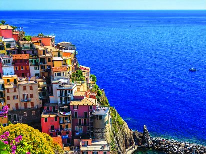 Amazing vineyard and colorful mediterranean flowers on the shore of the sea. Fantastic view from the hill with Manarola village and blue sea, Cinque Terre, Liguria, Italy, Europe