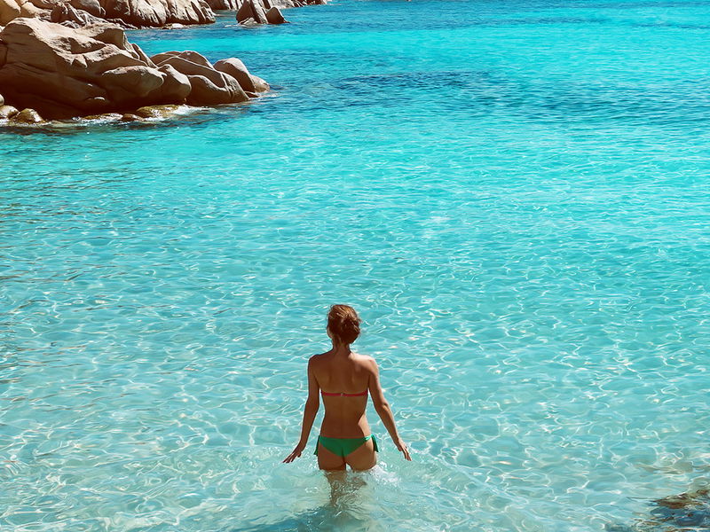 Woman stands in crystal clear water