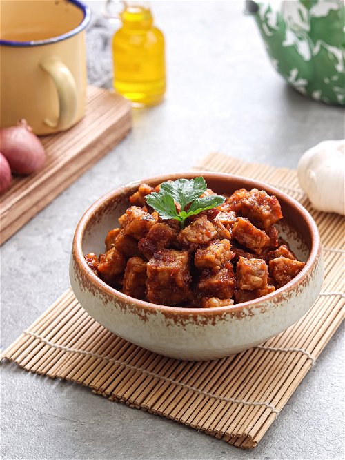 Tempeh kecap, or tempeh cooked with spices and sweet soy sauce.  Selected focus