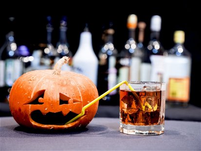 Halloween party. Funny Pumpkin with a cocktail