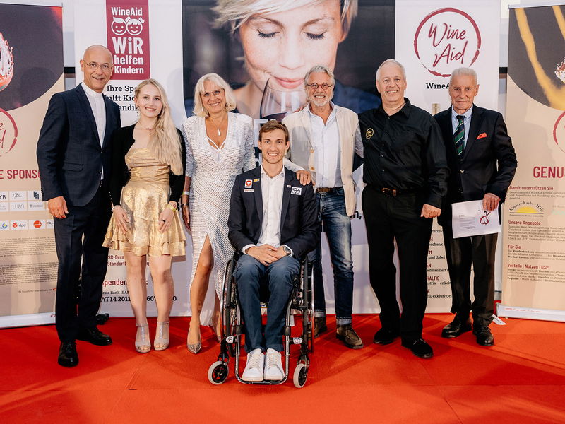 v. l.: Dompfarrer Toni Faber, Paraski-Athletin Elina Stary, Gabriele Aicher, Paraschwimmer Andreas Ernhofer, Schauspieler Adi Hirschal, WineAid-Initiator Thomas Schenk, Promi-Winzer Leopold Pfaffl.