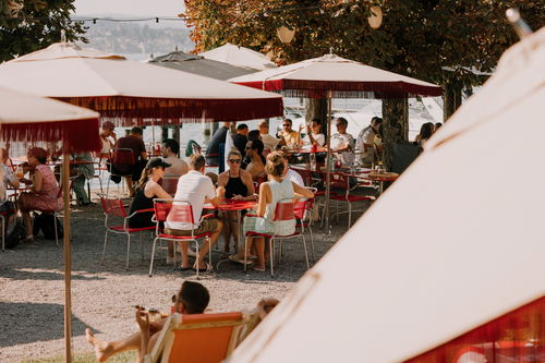 Sonnenschirme und Bäume schützen beim Essen vor der Sonne.