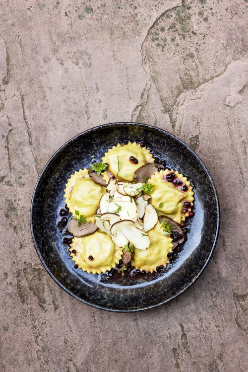 Ricotta-Spinat-Ravioli mit Steinpilzen und Wildschweinfilet.