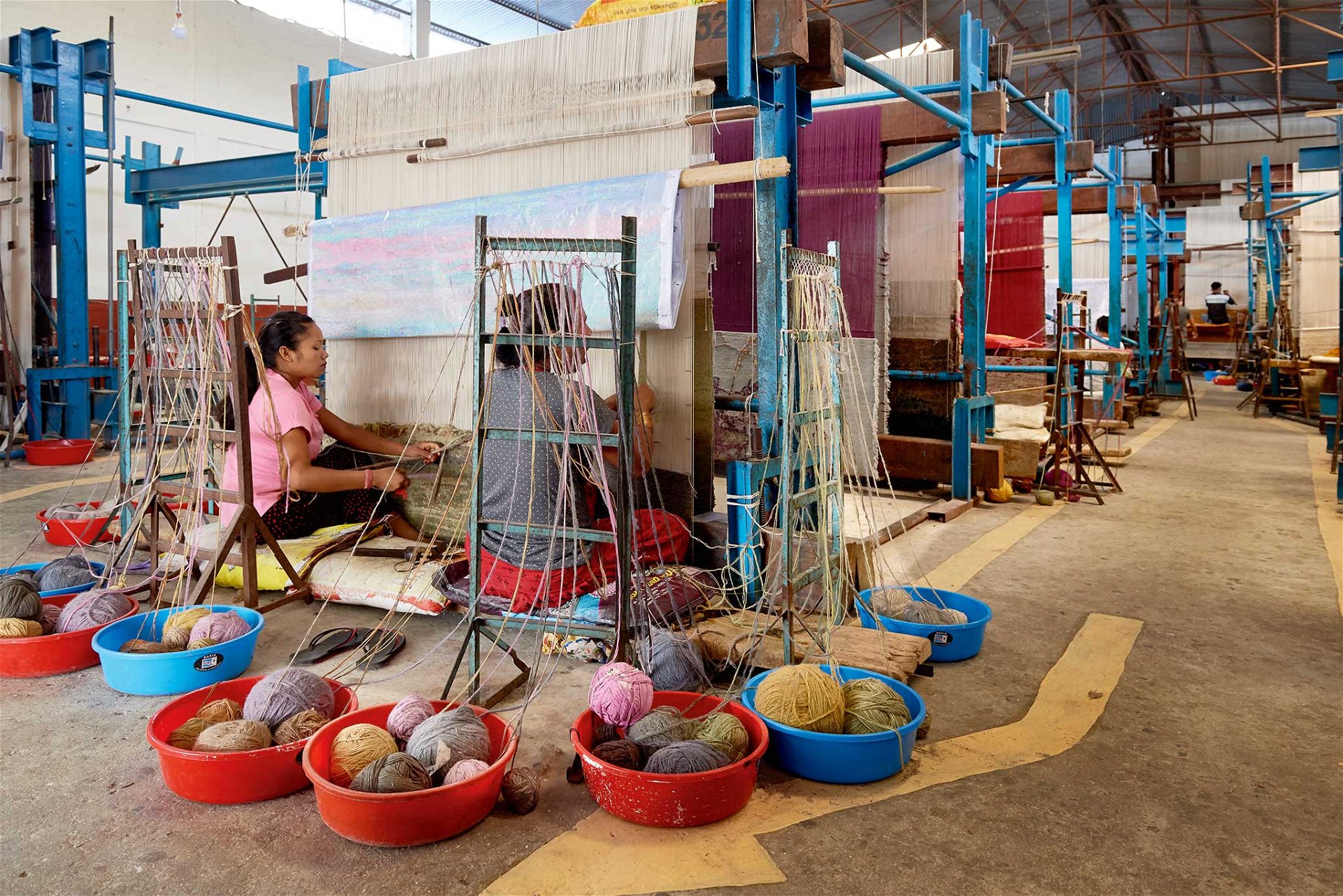 Nepal-Impressionen: Nepalesische Frauen beim Knüpfen der Teppiche. Meistens arbeiten sie noch in familiengeführten Betrieben.