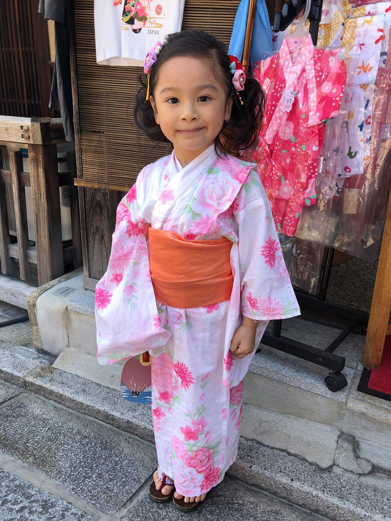 Ein kleines Mädchen präsentiert stolz ihren rosa Kimono. 