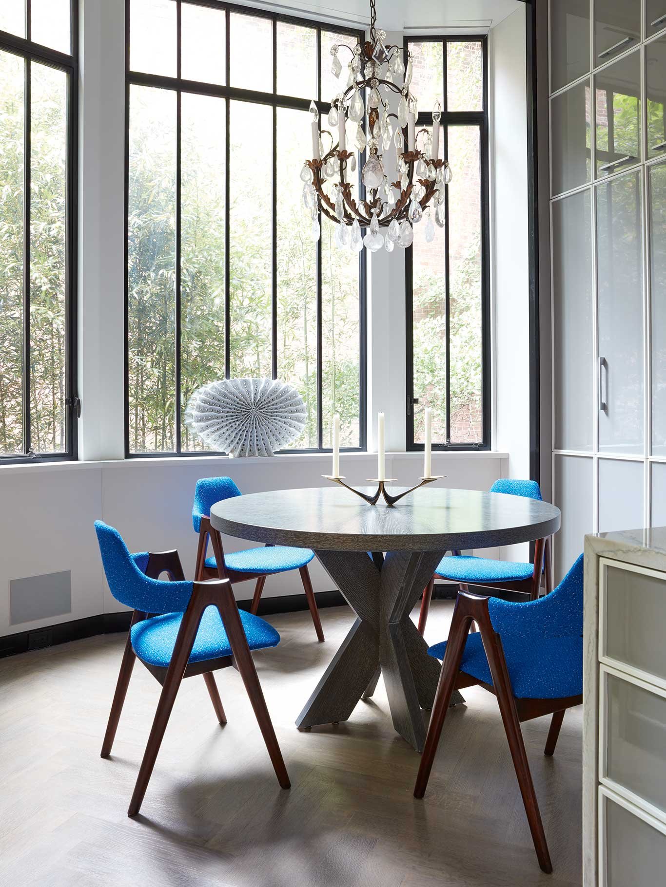 Der Tisch wurde von Eero Saarinen für Knoll designt, als Kontrastpunkt dienen neu überzogene Vintage-Stühle von Kai Kristiansen. Der Bergkristall-Luster stammt aus der Zeit von Louis XV.