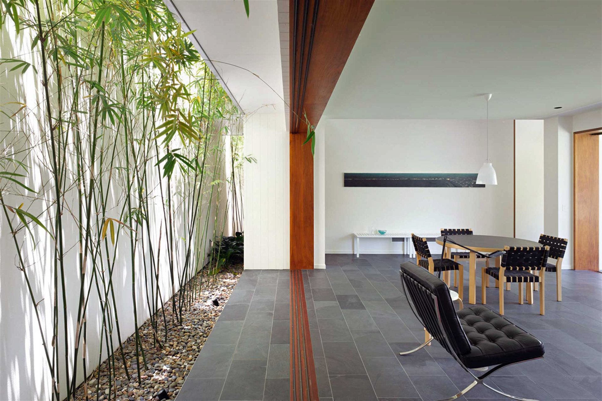 Der australische Architekt Shane Plazibat hat schon Wohnhäuser in London, Hongkong und Down Under geplant. Das Fig Tree Pocket House am Stadtrand von Brisbane blickt auf der einen Seite in einen großen Feigengarten, während auf der anderen Seite ein schmales Bambusatrium vor die Wohnzimmerrückwand eingeschnitten ist. plazibat.com.au