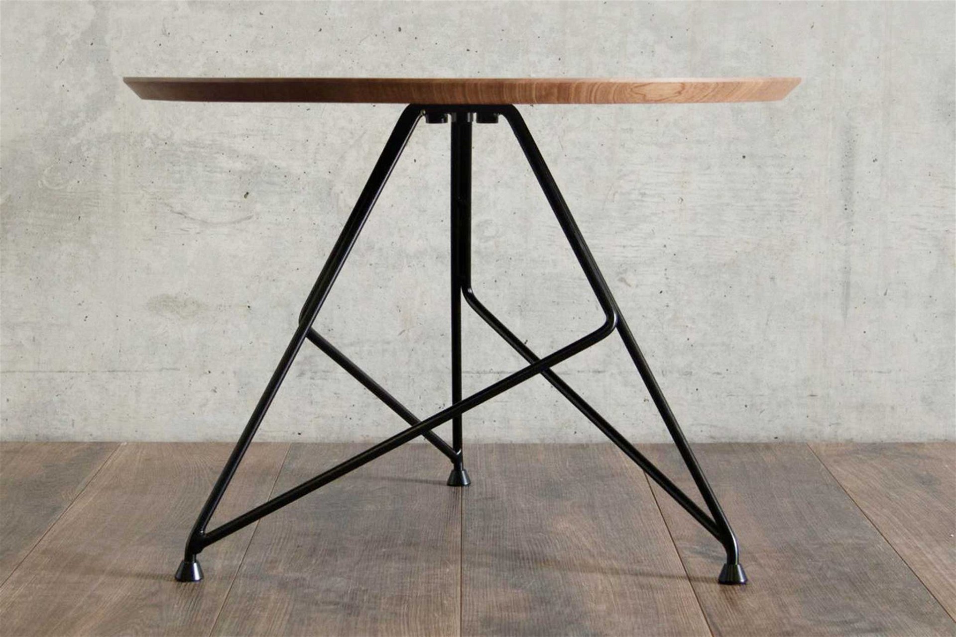 Das charakteristische Metallgestell trägt eine Tischplatte aus Walnuss-Massivholz. massimocappella.com
