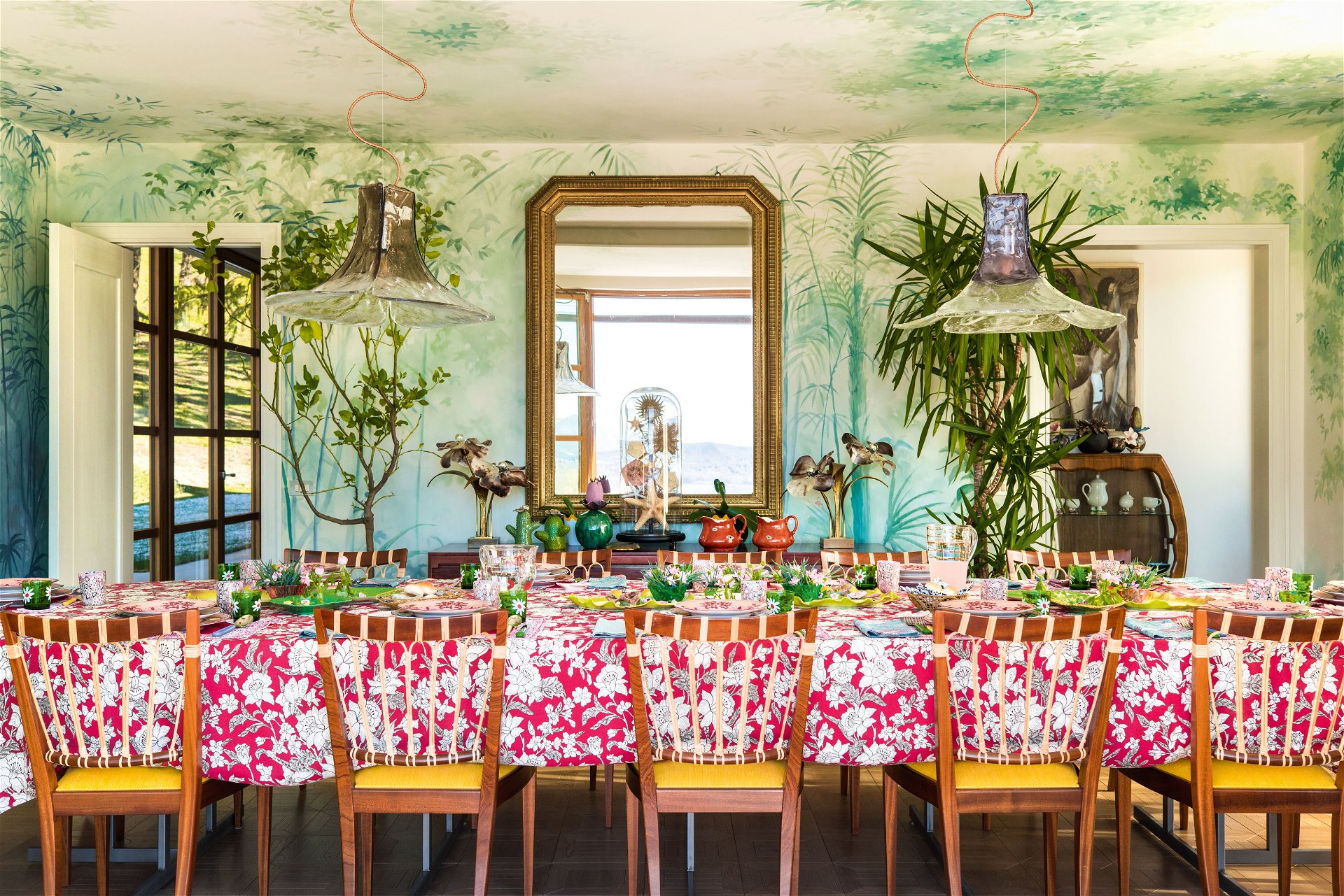 Frühstück im Grünen: Das Esszimmer verwandelt sich dank des maßgefertigten Wand­gemäldes in ein romantisches Gewächshaus. Entworfen wurde es von Pictalab Studio aus Mailand.