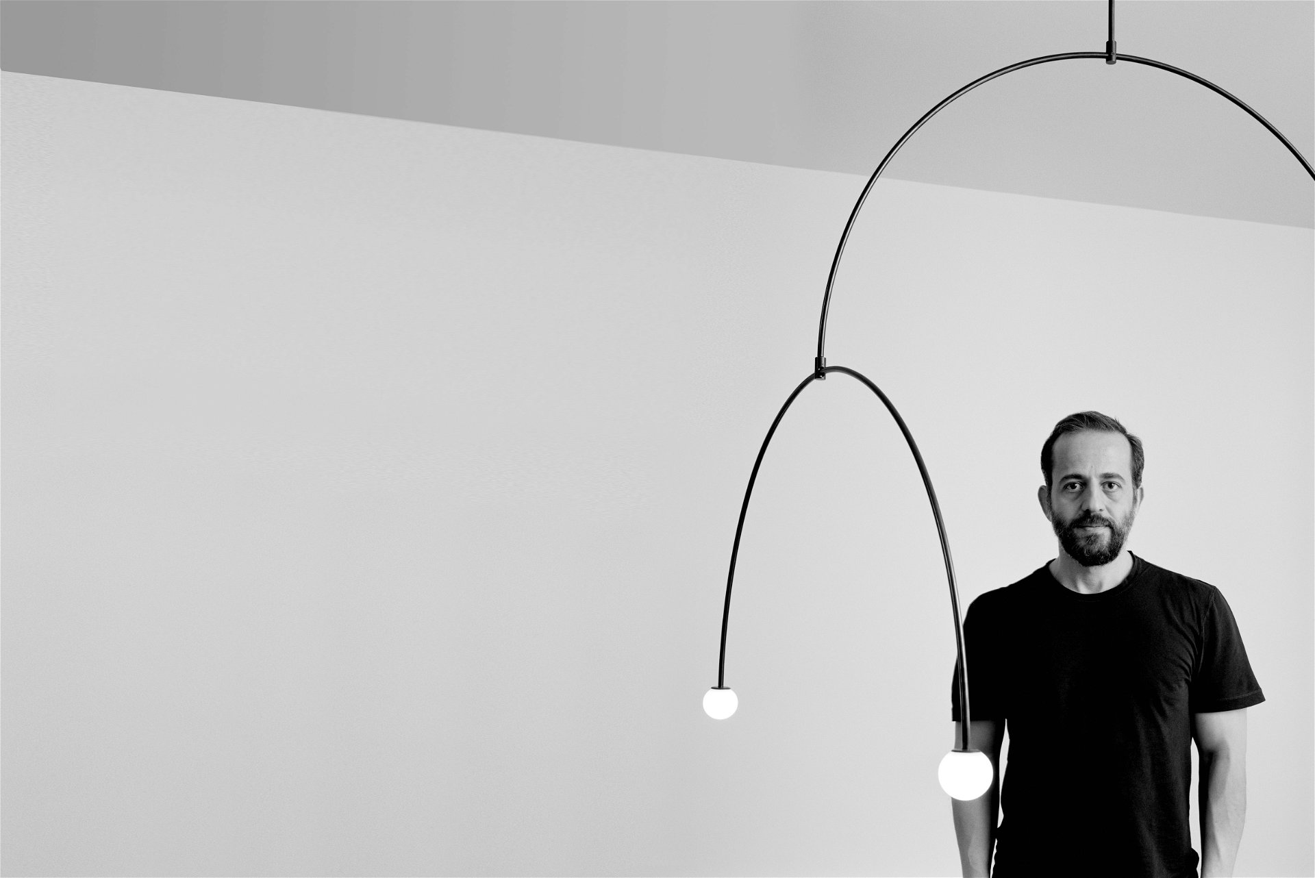 Balanceakt: Von Licht und Symmetrie beseelt: Designer Michael Anastassiades, geboren 1967 in Nikosia/Zypern, inmitten seiner Leuchte »Mobile Chandelier 9« (Flos). michaelanastassiades.com