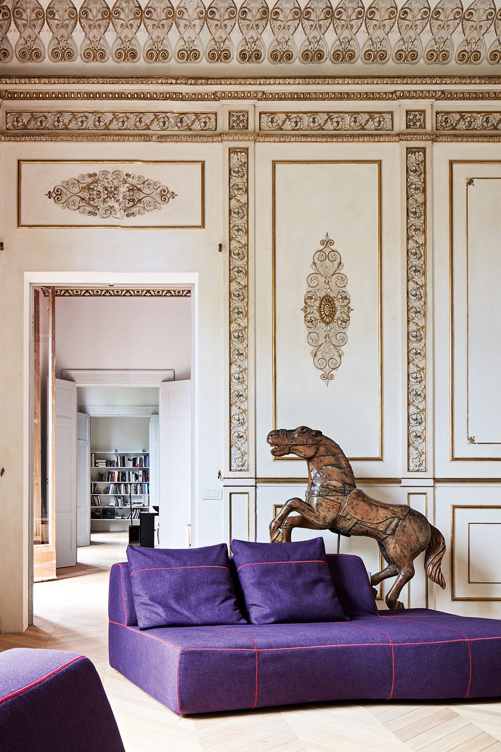 Das stilvoll-gemütliche Sofa hat die spanische Designerin Patricia Urquiola entworfen. Dahinter ein originales Karussellpferdchen aus Holz.