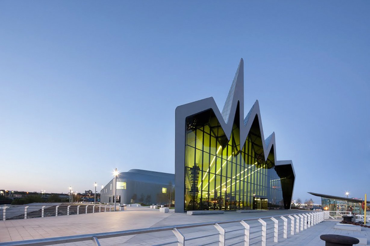 Riverside Museum, Glasgow Bewegte Zeiten, dynamische Architektur: Das Dach des von Zaha Hadid geplanten Verkehrsmuseums schaut zwar von der Seite aus wie eine Konjunkturkurve, bildet aber eine  wellige Konstruktion, die sich wie ein Fluss über das gesamte Gebäude fortsetzt.